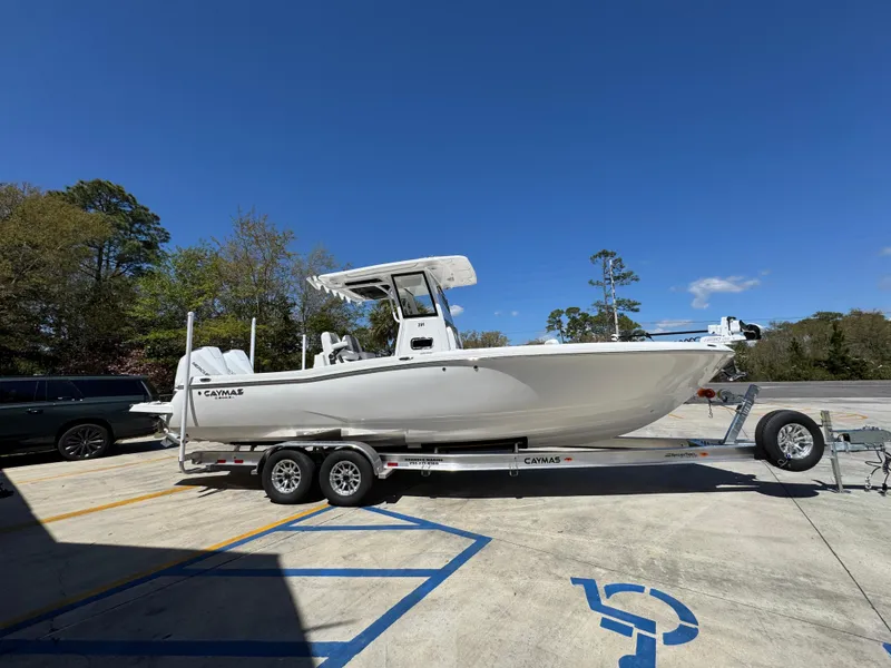 Slide: The Image of 2025 Caymas 291 boat on trailer in parking lot under clear blue sky. - 10