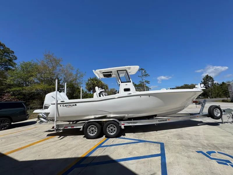 Slide: The Image of 2025 Caymas 291 boat on trailer, parked outdoors under clear blue sky. - 11