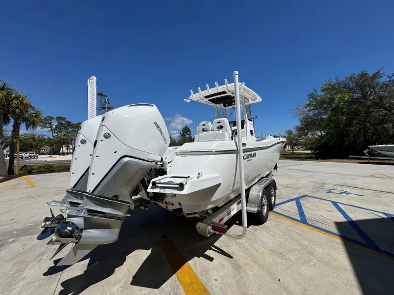 Slide: The Image of 2025 Caymas 291 boat with powerful outboard motor on trailer, parked outdoors. - 14