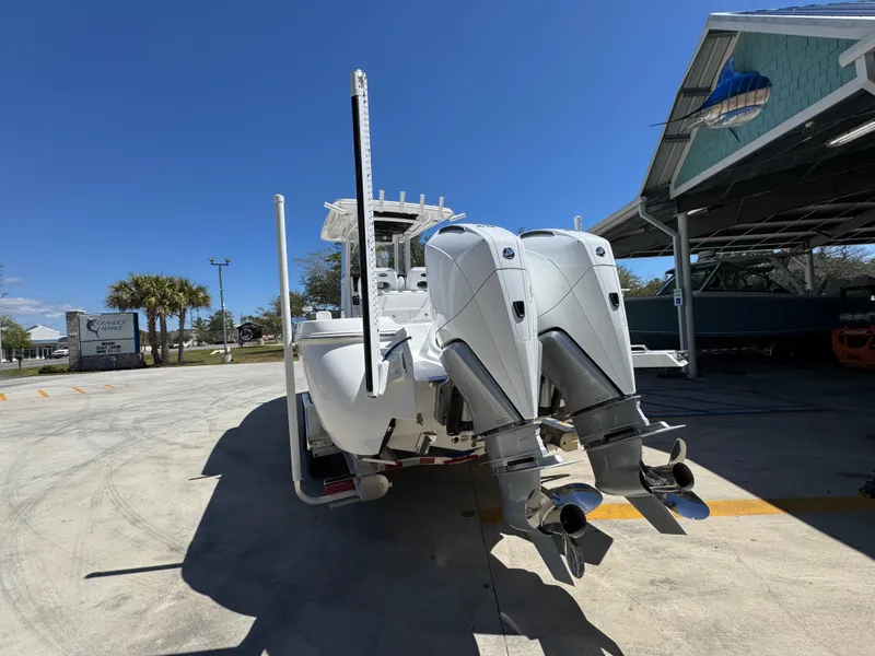 Slide: The Image of 2025 Caymas 291 boat with dual outboard motors in a sunny marina setting. - 18