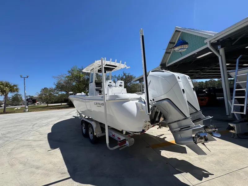 Slide: The Image of 2025 Caymas 291 boat on trailer, parked outdoors under clear blue sky. - 19