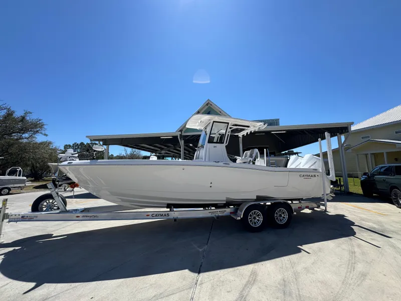 Slide: The Image of 2025 Caymas 291 boat on trailer under clear blue sky. - 2