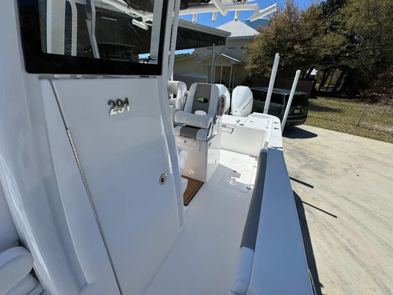 Slide: The Image of 2025 Caymas 291 boat, sleek white design, spacious deck, modern seating, outdoor setting. - 26