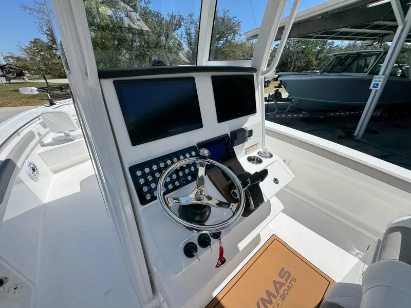 Slide: The Image of 2025 Caymas 291 boat dashboard with dual screens and steering wheel. - 32