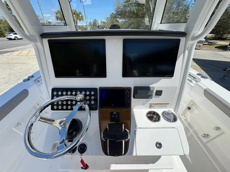 Slide: The Image of 2025 Caymas 291 boat dashboard with dual screens, steering wheel, and control panel. - 33