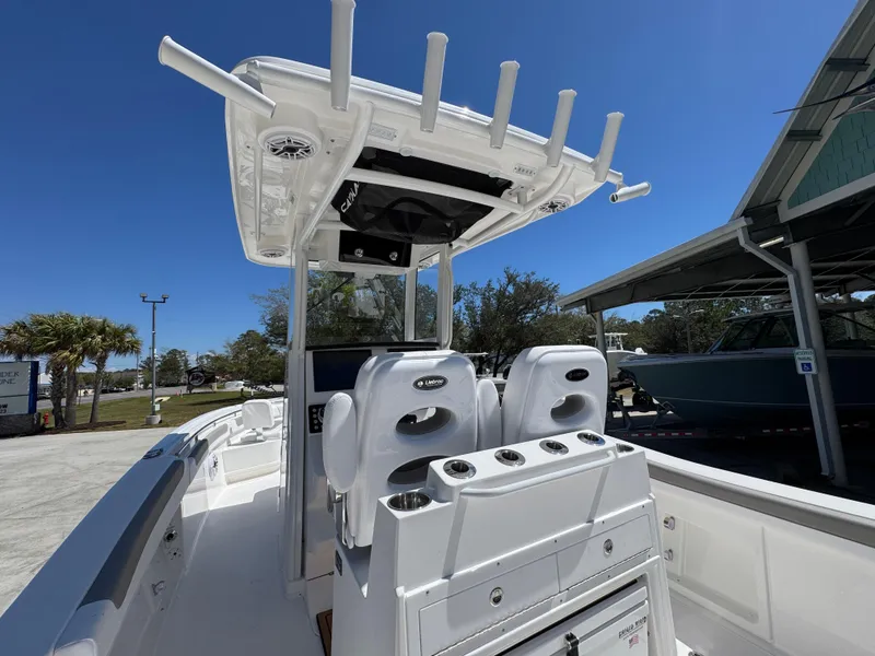 Slide: The Image of 2025 Caymas 291 boat interior with seating and rod holders under a clear blue sky. - 36