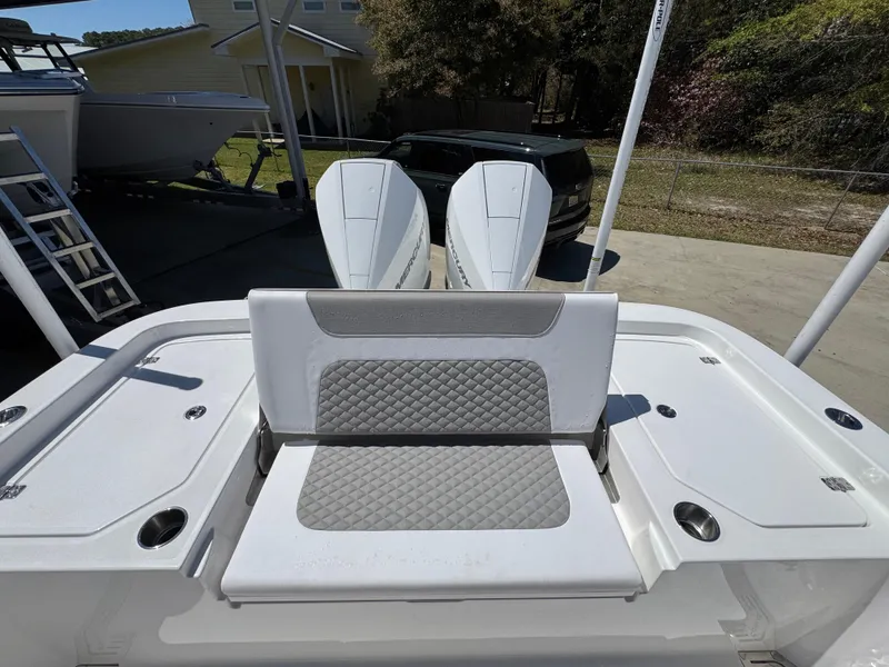 Slide: The Image of 2025 Caymas 291 boat with dual engines and cushioned seating, parked outdoors. - 39