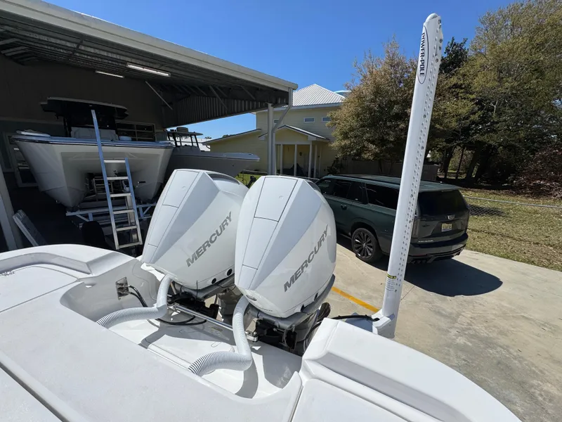 Slide: The Image of 2025 Caymas 291 boat with dual Mercury engines in a sunny outdoor setting. - 40