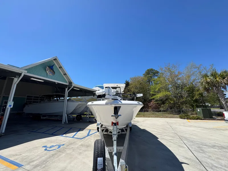 Slide: The Image of 2025 Caymas 291 boat on trailer outside a storage facility under clear blue sky. - 7