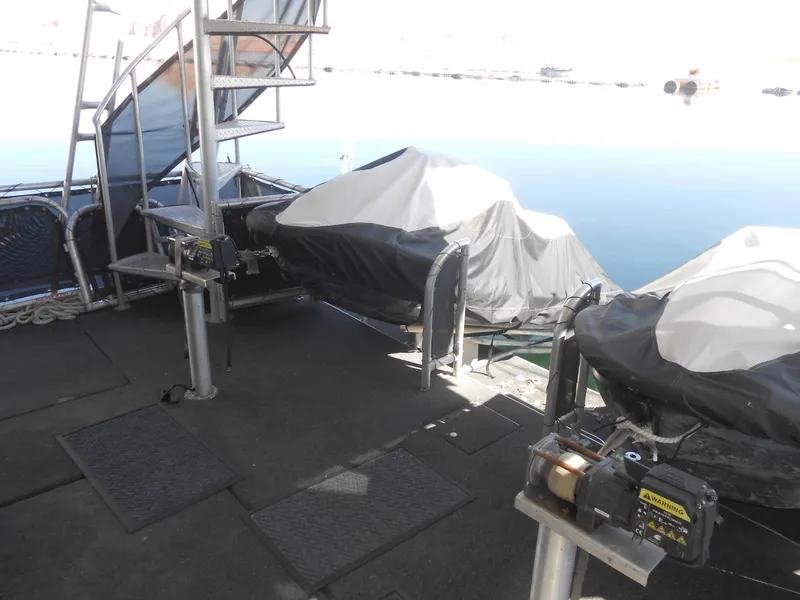 Slide: The Image of 2008 Sumerset 7518 houseboat deck with covered equipment and spiral staircase by the water. - 19