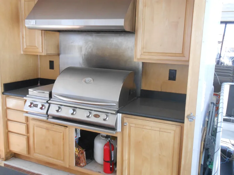 Slide: The Image of Outdoor kitchen with stainless steel grill, wooden cabinets, and fire extinguisher on a Sumerset 7518 houseboat. - 27