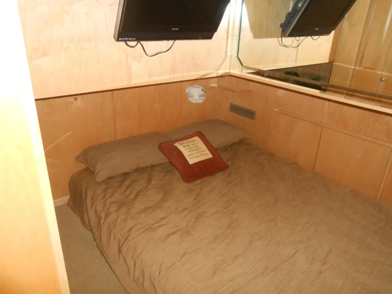Slide: The Image of Cozy bedroom in 2008 Sumerset 7518 houseboat with TV and brown bedding. - 5