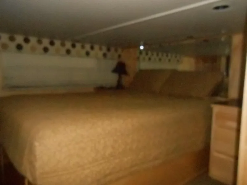 Slide: The Image of Cozy bedroom interior in 2008 Sumerset 7518 houseboat with patterned wall decor. - 7