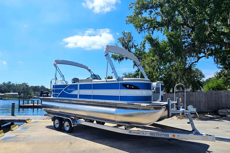 Slide: The Image of 2025 Bentley Pontoons Legacy Cruise 223 on trailer by lakeside, under clear blue sky. - 7