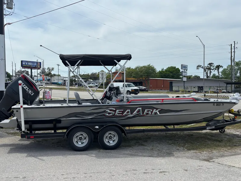 Slide: The Image of 2019 SeaArk Big Easy boat on trailer, parked outdoors with canopy and Suzuki outboard motor. - 1
