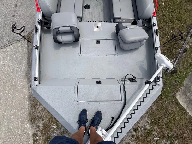 Slide: The Image of 2019 SeaArk Big Easy boat interior with gray seating and trolling motor. - 25