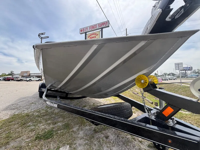 Slide: The Image of 2019 SeaArk Big Easy boat on trailer, parked near a fence supply store. - 31