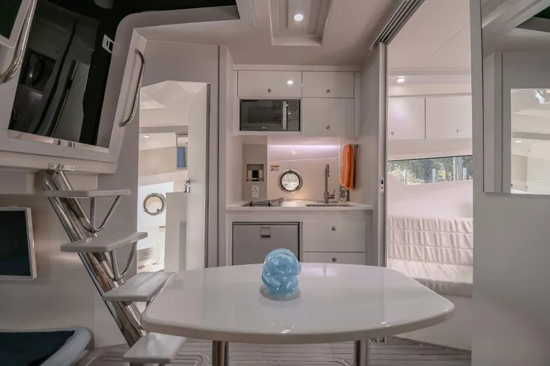 Slide: The Image of Modern Evolve 400HT yacht interior with kitchenette, dining area, and cozy seating, 2021 model. - 8