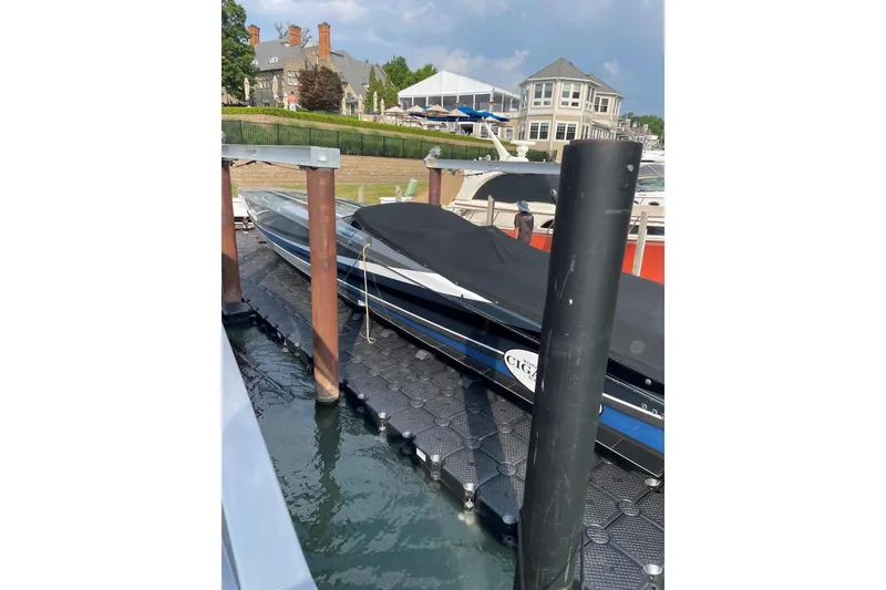 Slide: The Image of 2011 Cigarette 50' Marauder boat docked at marina with luxury homes in background. - 8