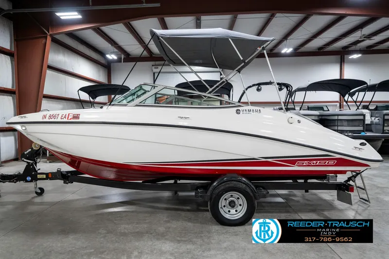 Slide: The Image of 2018 Yamaha SX190 boat in showroom, white with red accents, on a trailer. - 11