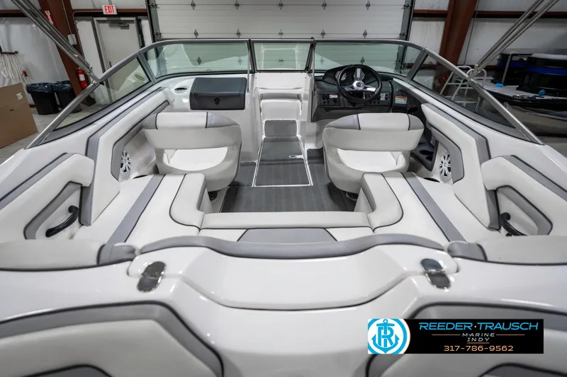 Slide: The Image of 2018 Yamaha Boats SX190 interior with white seating and steering wheel in a garage setting. - 16