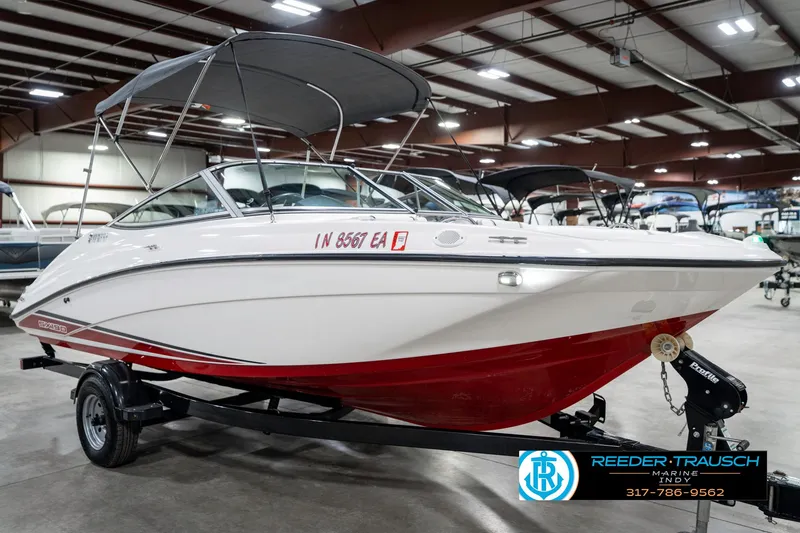 Slide: The Image of 2018 Yamaha Boats SX190 with red hull, displayed indoors on a trailer. - 6
