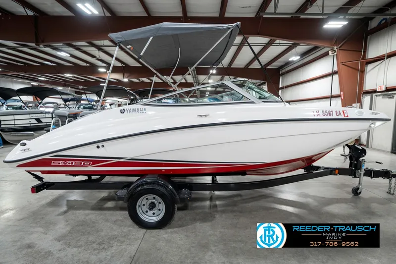 Slide: The Image of 2018 Yamaha Boats SX190 in showroom, white with red accents, on trailer. - 7