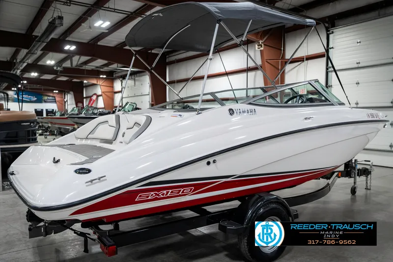Slide: The Image of 2018 Yamaha Boats SX190 in showroom, white with red accents, on trailer. - 8