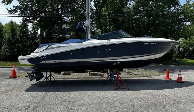 The Image of 2013 Sea Ray 270 SLX boat on stands, outdoors with traffic cones. - 0