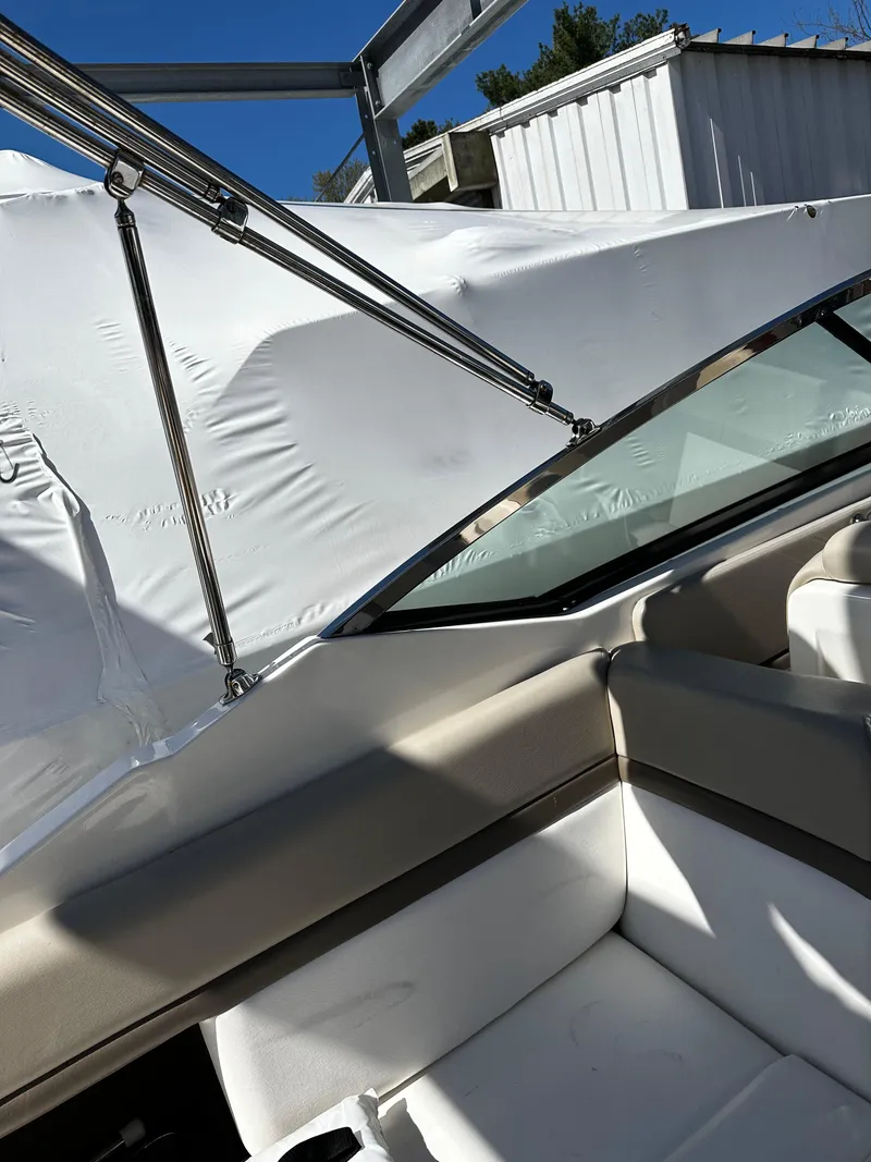 Slide: The Image of 2013 Sea Ray 270 SLX boat interior with white seating and protective cover. - 19
