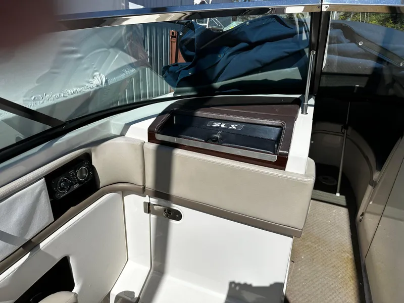 Slide: The Image of 2013 Sea Ray 270 SLX boat interior with beige seating and dashboard. - 9