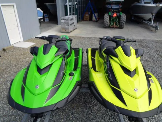 Slide: The Image of Two 2021 Yamaha WaveRunner VX Cruiser HO jet skis in green and yellow parked outdoors. - 2