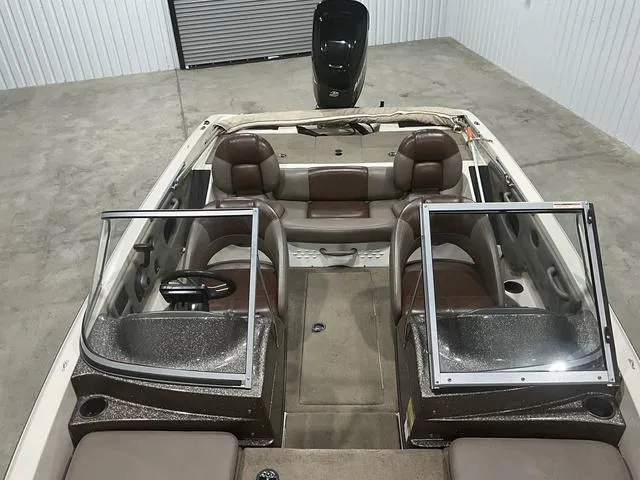 Slide: The Image of 2009 Ranger Reata 186 boat interior with brown seating and dual windshields in a garage. - 11