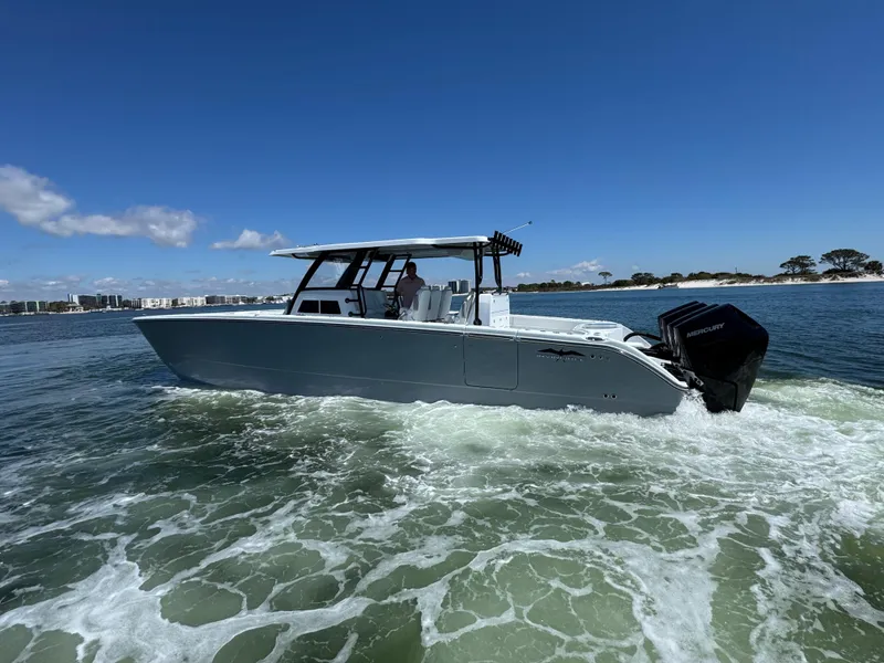 Slide: The Image of 2025 Invincible 40 Catamaran cruising on open water under clear blue skies. - 12