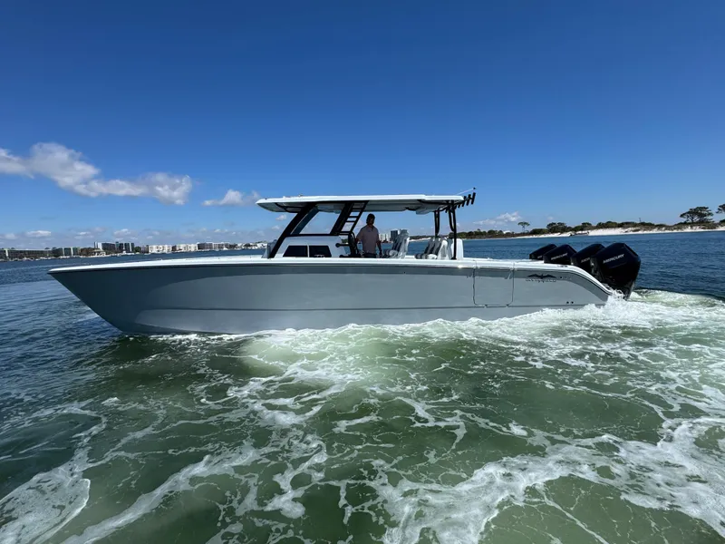 Slide: The Image of 2025 Invincible 40 Catamaran cruising on open water under clear blue skies. - 14