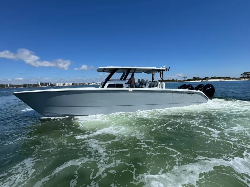 Slide: The Image of 2025 Invincible 40 Catamaran cruising on open water under clear blue skies. - 15