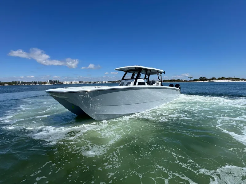 Slide: The Image of 2025 Invincible 40 Catamaran cruising on open water under clear blue skies. - 18