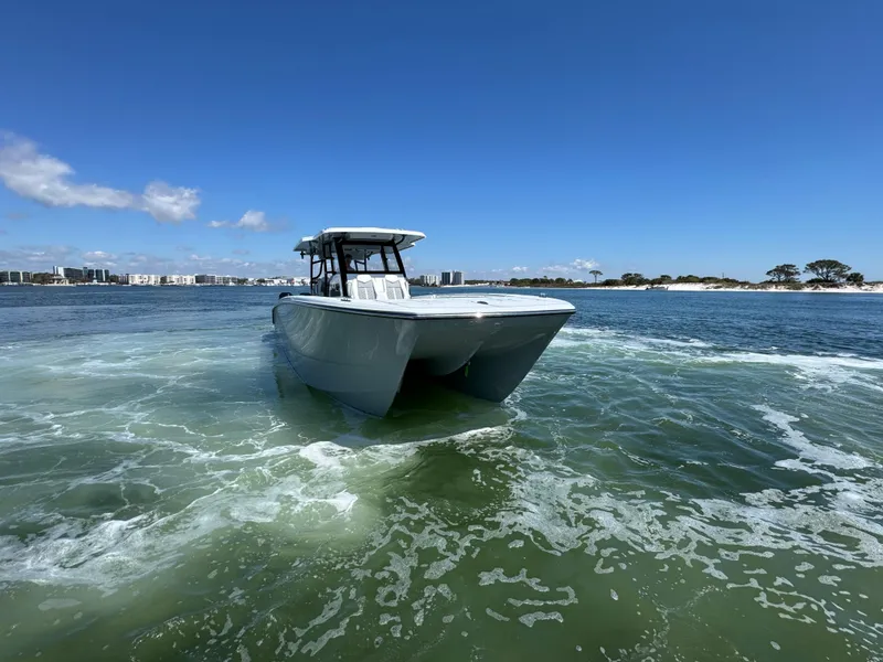 Slide: The Image of 2025 Invincible 40 Catamaran cruising on open water under clear blue skies. - 19