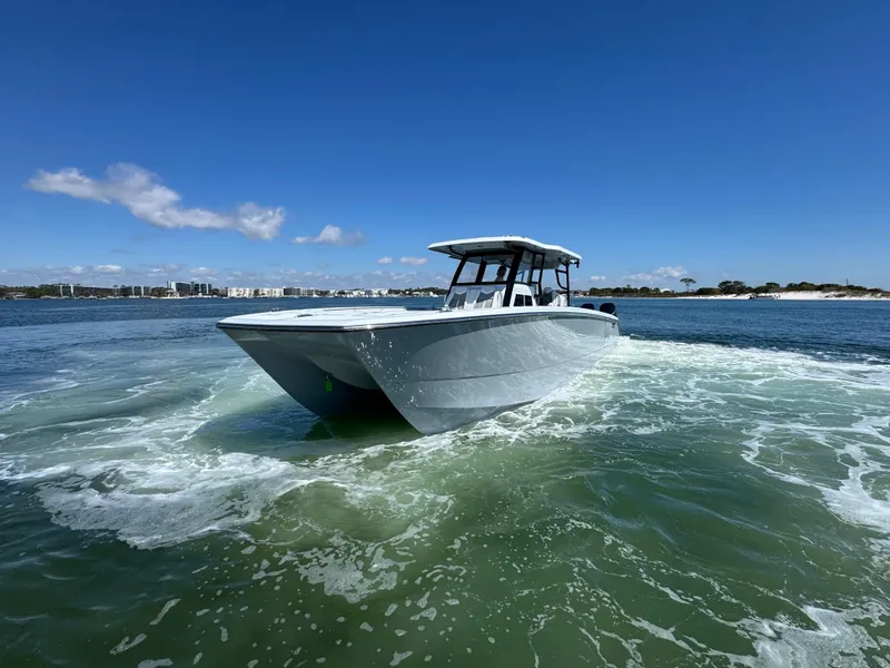 Slide: The Image of 2025 Invincible 40 Catamaran cruising on open water under clear blue skies. - 20