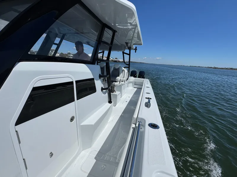 Slide: The Image of 2025 Invincible 40 Catamaran cruising on open water under clear blue skies. - 27