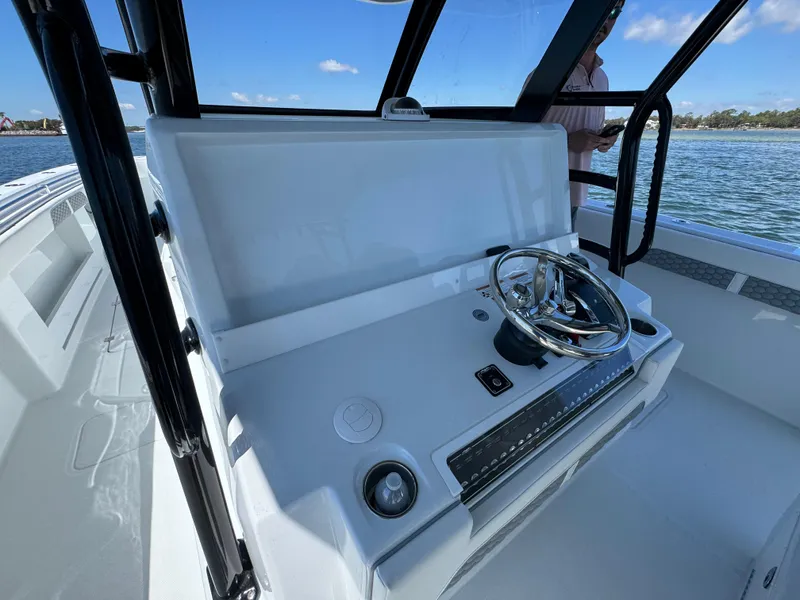 Slide: The Image of 2025 Invincible 40 Catamaran helm with steering wheel and controls, on open water. - 32