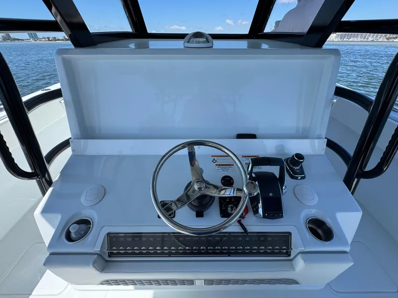 Slide: The Image of 2025 Invincible 40 Catamaran helm with steering wheel and controls, overlooking the ocean. - 33