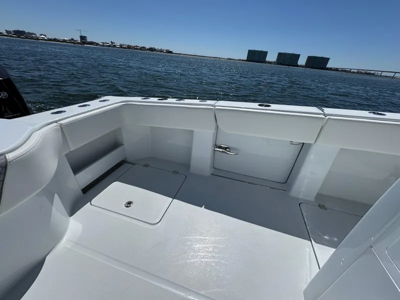 Slide: The Image of 2025 Invincible 40 Catamaran deck with ocean view, featuring sleek white design and storage compartments. - 38
