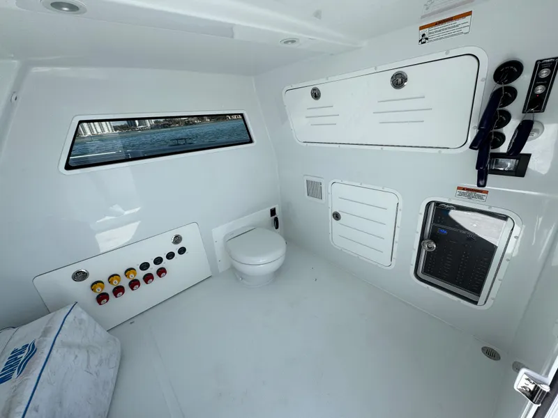 Slide: The Image of Interior of 2025 Invincible 40 Catamaran featuring a modern marine toilet and control panel. - 43