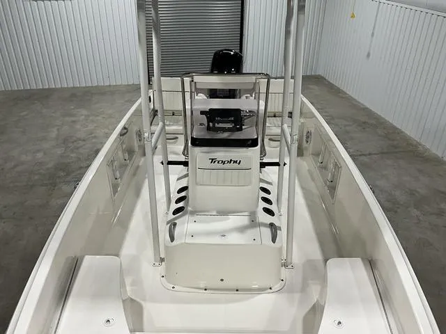 Slide: The Image of 2021 Bayliner T21BAY boat interior, featuring center console and spacious deck in a storage facility. - 13