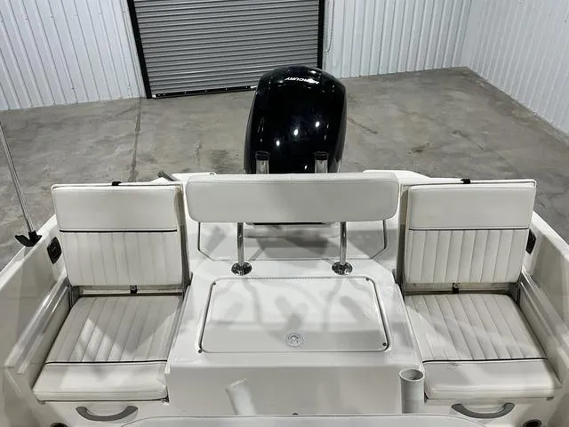 Slide: The Image of 2021 Bayliner T21BAY boat interior with seating and motor in a garage setting. - 14