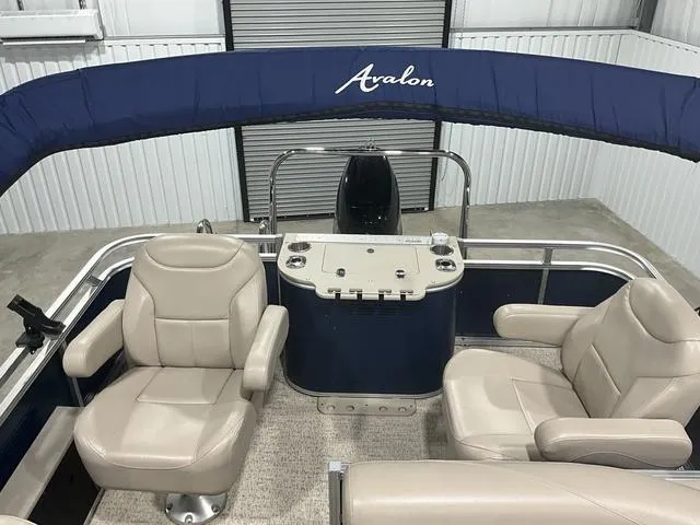 Slide: The Image of 2019 Avalon 22 LSZ pontoon boat interior with beige seating and blue canopy. - 10