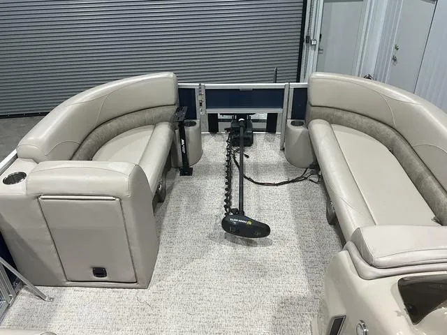 Slide: The Image of 2019 Avalon 22 LSZ pontoon boat interior with beige seating and trolling motor. - 12