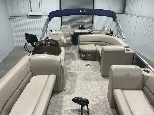 Slide: The Image of 2019 Avalon 22 LSZ pontoon boat interior with beige seating and helm. - 6