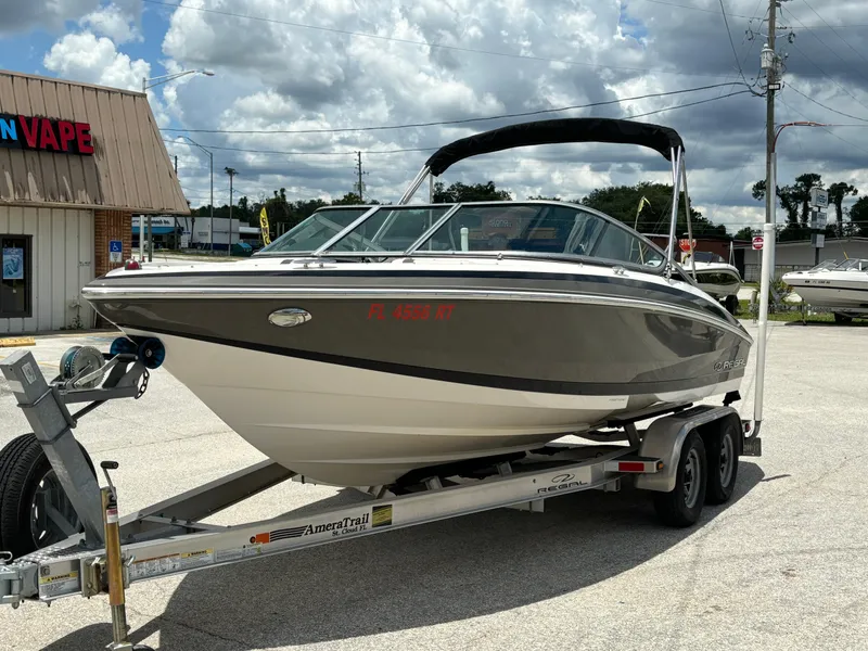 Slide: The Image of 2016 Regal 2100 RX Bowrider on trailer, parked outdoors under cloudy sky. - 4